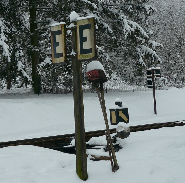 winterliches Stillleben mit den Gerätschaften zur Weichenreinigung